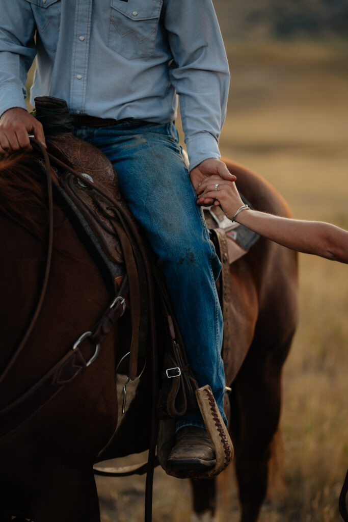 two people holding hands while one is on horseback